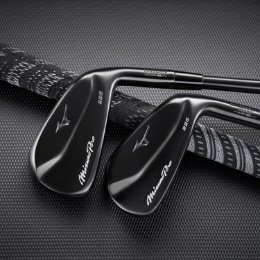 Two Mizuno Pro 225 Black ION lying on black background both back side up on top of black golf club grip