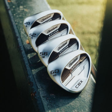 Cleveland CBX ZipCore Golf Wedges lying on wood with the back of the club head of all clubs visible. 