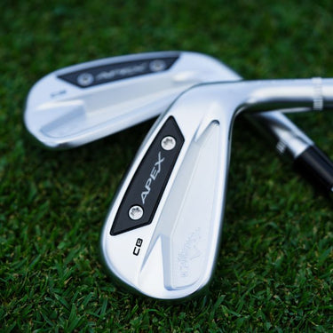 Two Callaway Apex CB 24 Golf Irons lying the heads over each other. Lying on grass. 