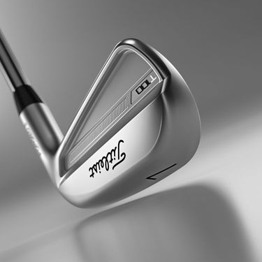 Titleist 2023 T100 Golf Irons being shown from jsut behind and below the toe of the club on a grey background. 