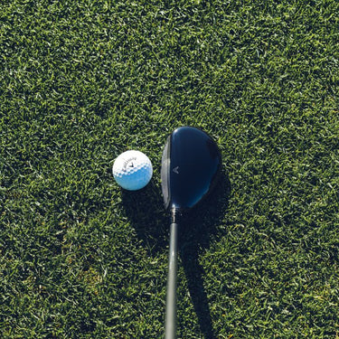 Callaway Paradym Golf Hybrid at the address of a Callaway Golf Ball looking down from above 