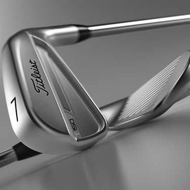 Titleist 2023 T150 Golf Irons lying on top of eachother one with the back of the club head showing and one with the face. On a silver background